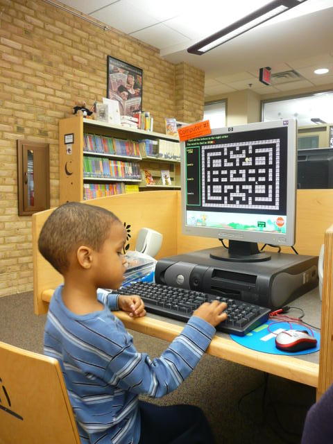 picture of child using computer in library